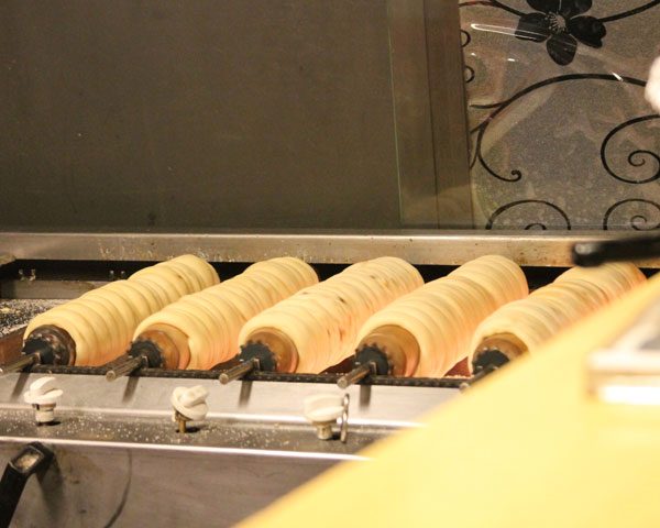 Trdelnik (a Czech pastry covered in cinnamon sugar) cooked over agas fire in Prague