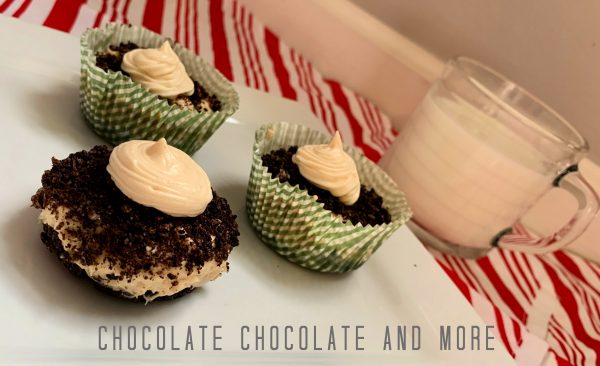 Peanut Butter Pie Cups One unwrapped peanut butter pie cup and two wrapped peanut butter pie cup sitting on a square white plate and a clear mug filled with milk on a red and white striped cloth and gray and white background.