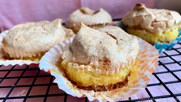 Vanilla Wafer meringue Pie Cups sitting on a metal cooling rack with a pink background.
