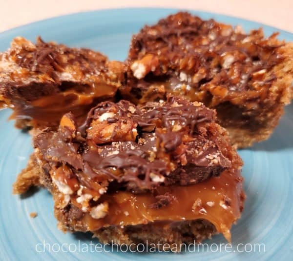 Three slices of Chocolate caramel pretzel bars on a blue plate