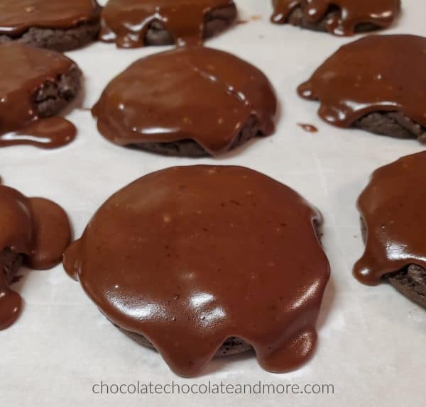 several chocolate iced cookies cooling on a counter