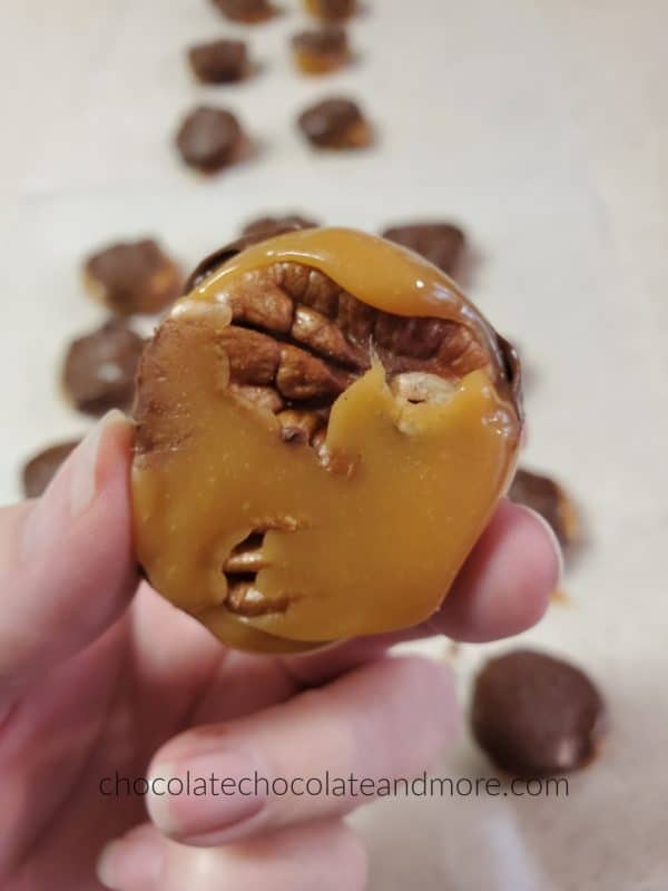 the bottom view of a candy showing the pecans coated with caramel