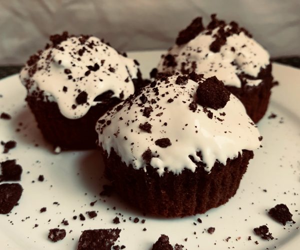 3 Frosted Oreo Brownie Cups sitting on a white plate in front of a white background.