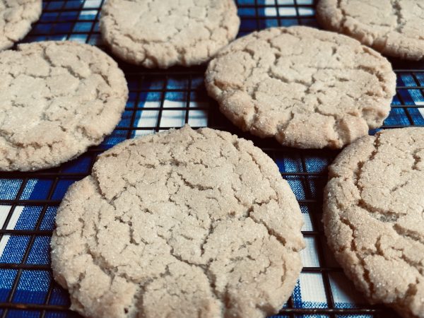 7 Cream Cheese Frosted Sugar Cookies sitting on a blue and white checkered background.