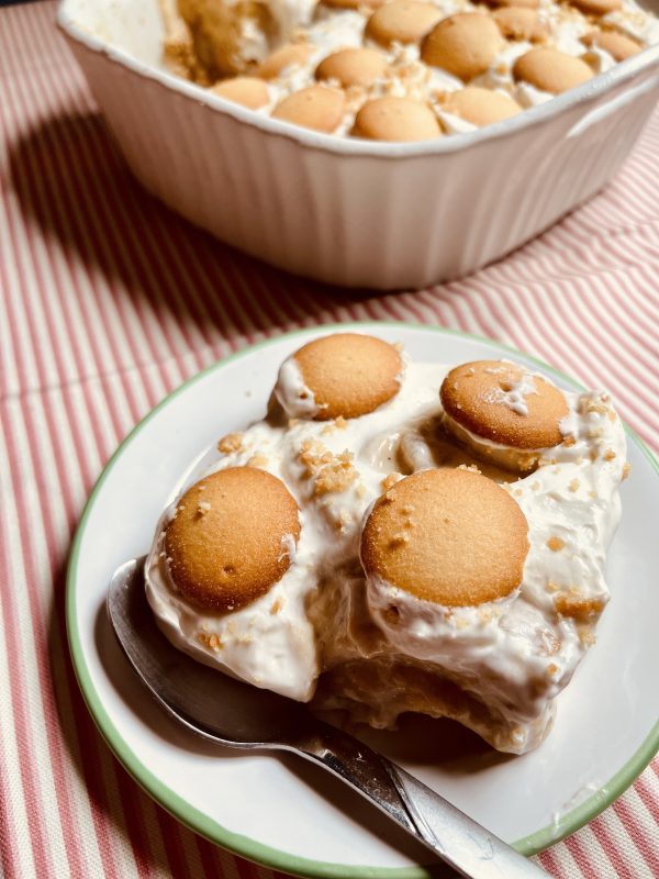 A plate of Banana Pudding Bars sitting in front of the dish of Banana Pudding Bars.
