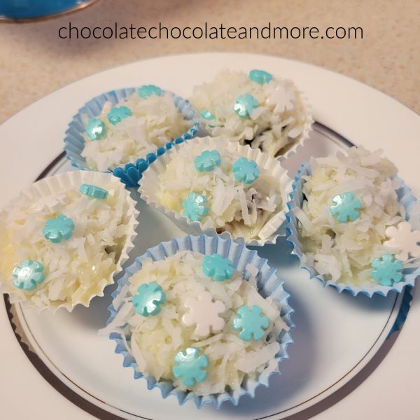 a plate of date snowballs with blue and white sprinkles