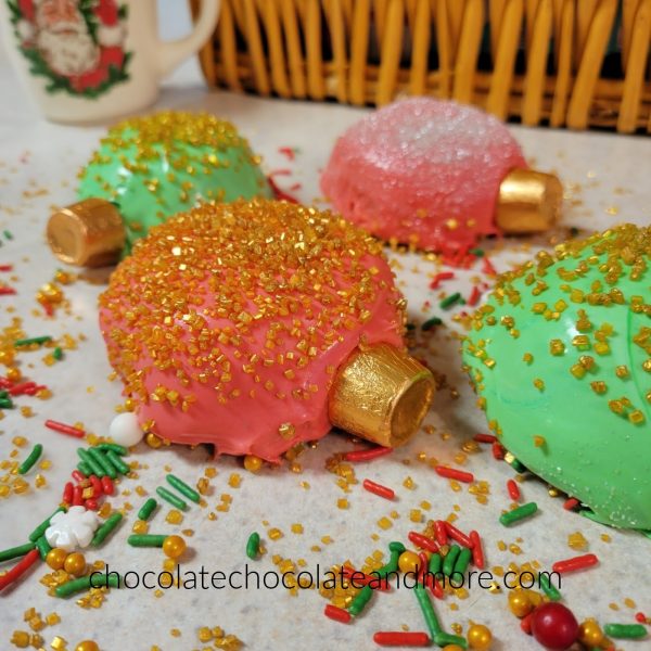 several ornament shaped cupcakes covered in sprinkles