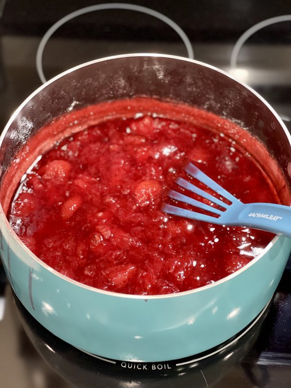 Strawberry syrup in a pot on the stove.
