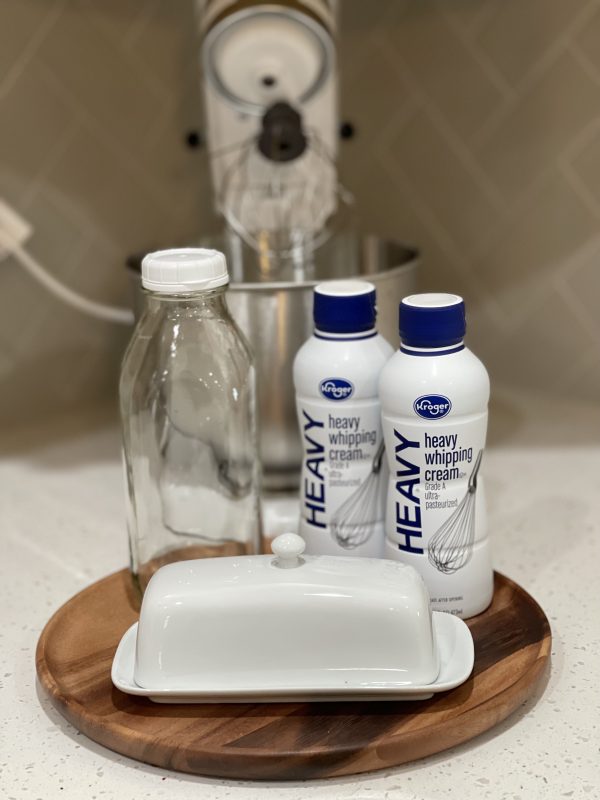 Stand mixer, heavy cream, empty milk jug, and butter container.