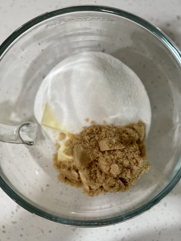 Butter, brown sugar and granulated sugar in a glass bowl.