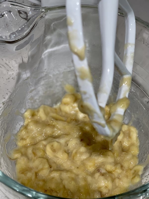 mashed bananas in a clear mixing bowl