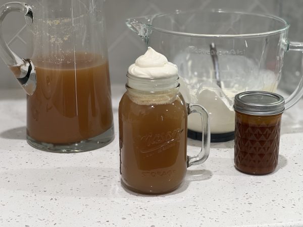 ButterBeer in a mason jar cup, in a pitcher, and a glass mixing bowl with the cream topping.