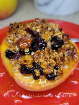 baked apple topped with crunchy granola on a red plate
