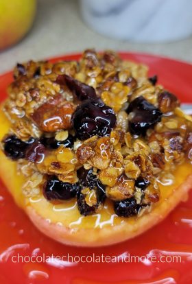baked apple topped with crunchy granola on a red plate