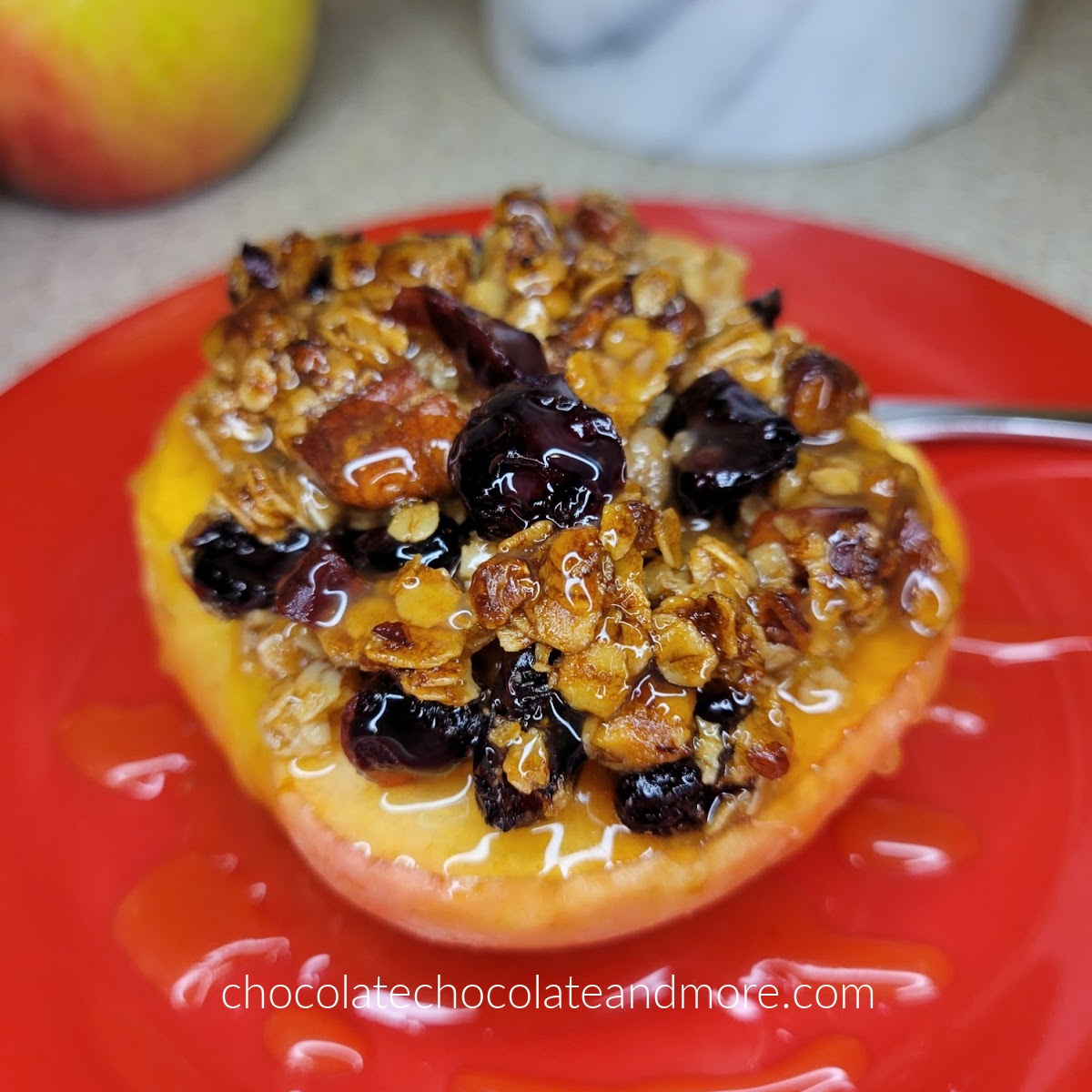 baked apple topped with crunchy granola on a red plate