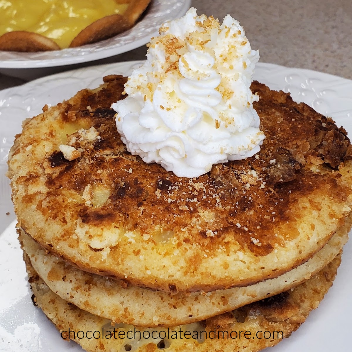 Banana Pudding Pancakes pancakes stacked and topped with whipped cream and wafer crumbs