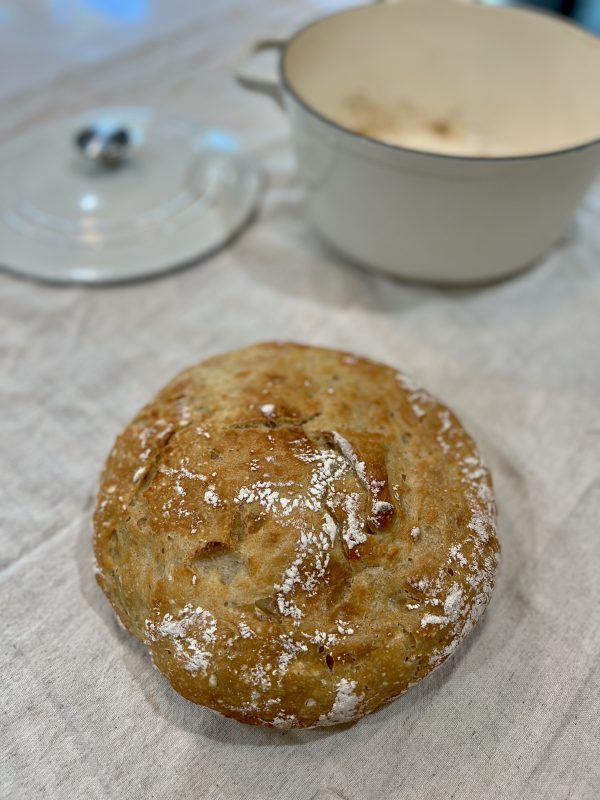 No-Knead Dutch Oven Bread on a towel in front of the dutch oven