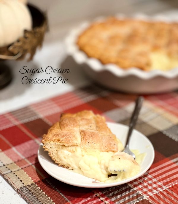 Sugar Cream Crescent Pie on a plaid table setting with the pie plate behind it