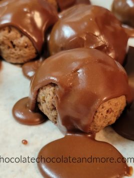 several chocolate ball cookies covered in chocolate icing
