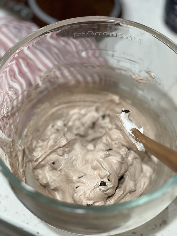 egg whites with the chocolate chips and hot cocoa mix folded in in a glass bowl