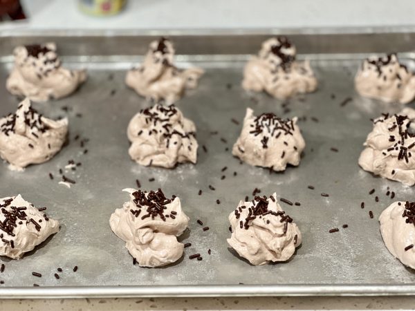 Hot Cocoa Meringue Cookies spoons on to a cookie sheet with sprinkles on top before baking