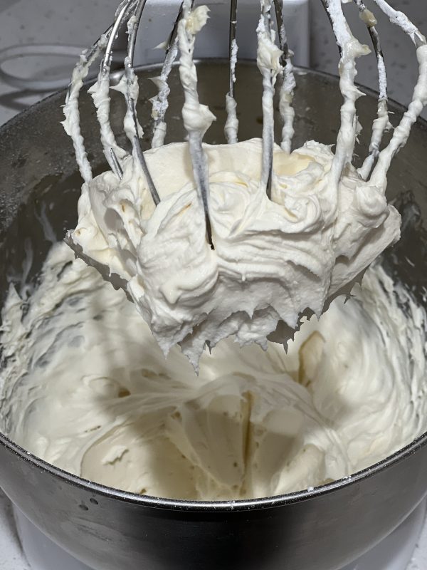 the frosting in a mixing bowl with the whisk attachment