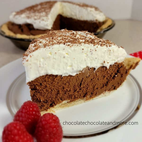 A slice of chocolate French silk pie topped with thick whipped cream