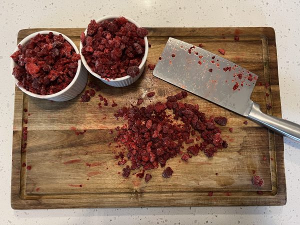 chopped raspberries on a wooden cutting board